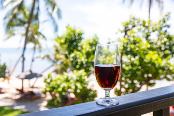 glass of red wine served on outdoor terrace with beautiful romantic  beach and sea view