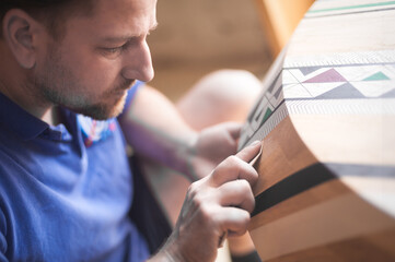 Obraz premium Master in the workshop. Man polishing wood with sandpaper. Carpentry concept with wood