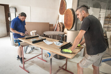 Two carpenters making furniture in a workshop. Woodworking and crafts tools