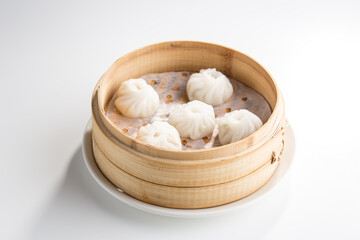 Chinese dim sum dumplings in bamboo basket isolated on white background