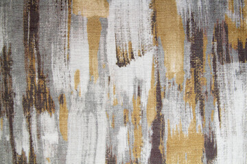 Abstract fabric pattern with embroidery on gray and white,golden, fabric. Background texture for the design.