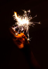 hand holding a sparkler in the dark 