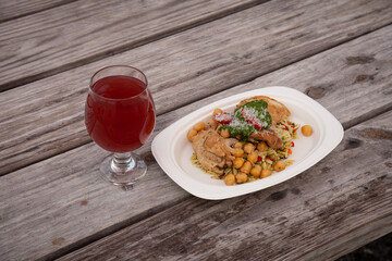 Glass of Cider and a plate of organic chicken, chickpeas, rice, Mediterranean style, brewery and food truck