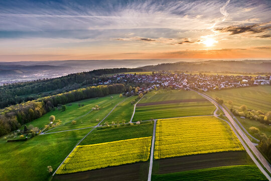 Germany, Baden Wurttemberg, Aerial view of agricultural fields in Swabian forest at sunrise
