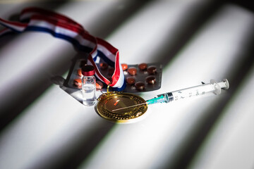 Champion's gold medal, syringe with doping substance, pill tablet and vial with prohibited...