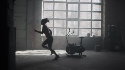 Sports woman standing at start position in gym. Athlete running in loft building