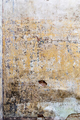 the remains of the painting of the walls of an abandoned temple are in terrible condition