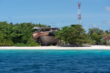 dilapidated hangars with ships on the shore of a coral island