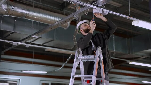 electrical works in industrial premises, electrician is installing junction box