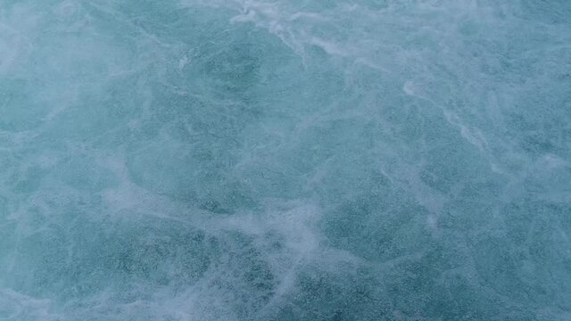 streams of water seethe in powerful waterfall, historic dam on Reuss river flowing from Lake Lucerne in switzerland, top view of stream bubbles, rippled liquid textured surface background