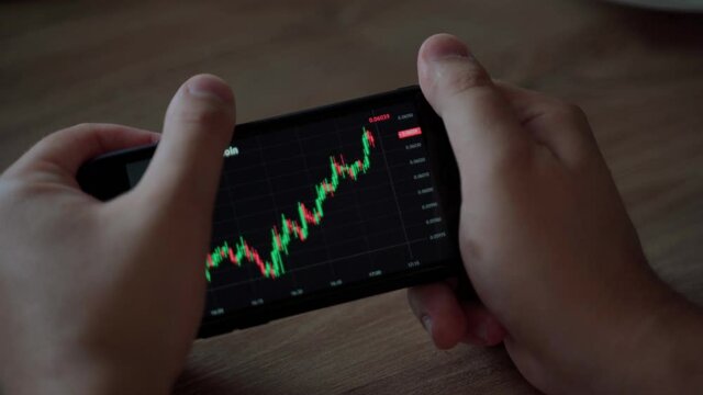 Man hold smartphone look graph of crypto currency online. Quotes of eth and btc at stock exchange. Stock exchange market chart of ethereum. Screen view at the app on the phone