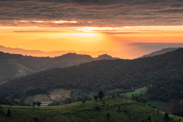 Scenery of colorful sunrise over mountain farmland in countryside