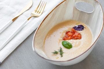Vegetable cream soup in bowl on gray table