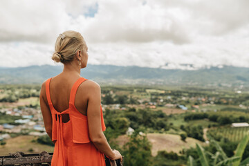 Naklejka na ściany i meble Young woman tourist in orange dress enjoying amazing view at Yun Lai Viewpoint