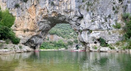 river in tthe gorges of the Ardèche in France with canoe under a arch in  the cliff