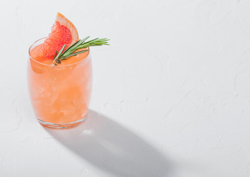 Red Grapefruit Cocktail With Fruit Slice And Rosemary On White Background.