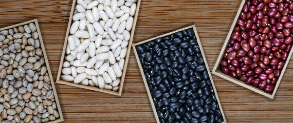 Red, black, white and carioca or pinto beans in wooden box on the wood table in Brazil