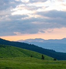 Fototapeta premium sunset in the mountains with distant mountains silhouettes