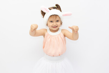 Charming girl in dress and white ears posing as cute bunny on gray background