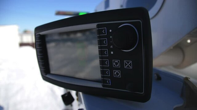 Control panel of boom lift truck with blank screen lever and buttons on construction site on sunny winter day extreme close view