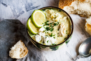 Bowl of Greek�avgolemono�soup with rice, lemon slices and bread