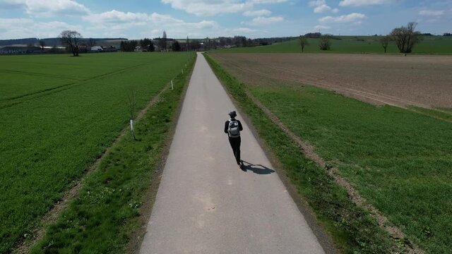 Overhead view of man riding an eletric scooter on a scenic rural road, near Svitavy in the Czech Republic