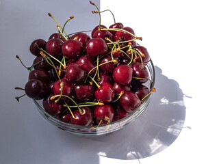 Sweet cherries in a transparent bowl in partial shade