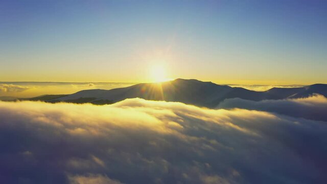 Wonderful view of extraordinary cloudy valley and bright orange sunset