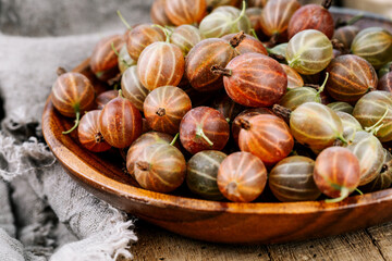 Red gooseberries on a wooden table.