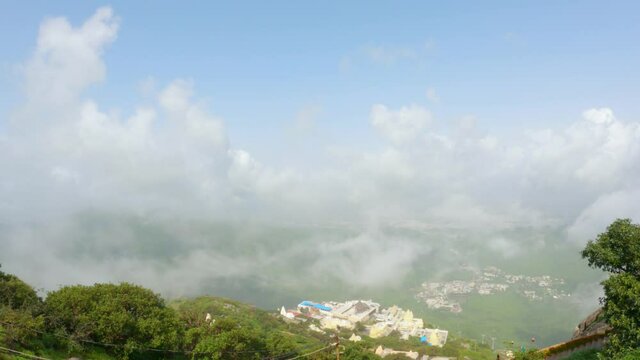 4k Footage. Timelapse of the clouds cover Neminath Jain temple and Junagadh city, View from Girnar hills . A sea of fog is formed over city. Foggy valley mount ridge nature 