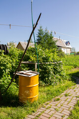 Fototapeta na wymiar yellow garden barrel for collecting rainwater in the garden