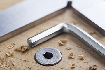 hex bolt screw by hex wrench in wooden oaks plate with with vernier caliper and ruler