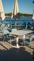 empty restaurant tables next to ocean