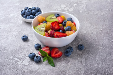 Bowl of healthy salad with fresh fruits and berries