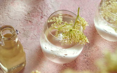 Elder flowers in a glass of lemonade with elder flower syrup