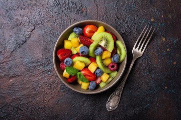 Bowl of healthy salad with fresh fruits and berries