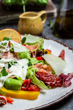 Healthy balanced lunch, Smoked salmon, lettuce, sun-dried tomatoes and cheese sauce, vertical image. top view