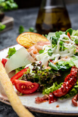 Smoked salmon, avocado and lettuce, sun-dried tomatoes and cheese sauce. Healthy salad. Top view