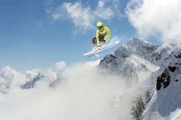 Skier jumps in the mountains. Mountain ski, winter extreme sport.