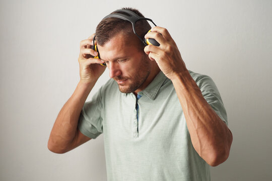 Portrait Of A Man Wearing Protection Yellow Ear Muffs. Noise Cancellation Headphones.