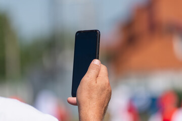 A man is looking for a cellular network with a telephone.