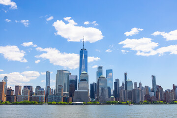 Unique shape clouds float over the Lower Manhattan skyscraper in springtime at New York City NY USA on May 14 2021. Image was taken from Jersey City NJ. - obrazy, fototapety, plakaty