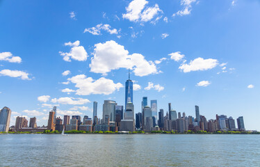 Fototapeta na wymiar Unique shape clouds float over the Lower Manhattan skyscraper in springtime at New York City NY USA on May 14 2021. Image was taken from Jersey City NJ.