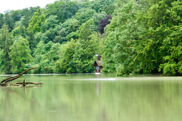 Fototapeta na wymiar Idyllik house at a lake surrounded by green trees