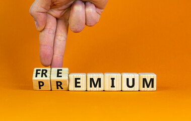 Premium or freemium symbol. Businessman turns wooden cubes and changes the word 'premium' to...