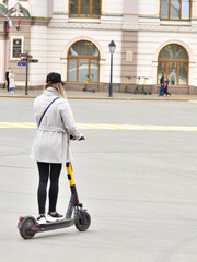 A girl tourist on an electric scooter rides on the street of the city. Russia Kazan 24.04.2021. High quality photo