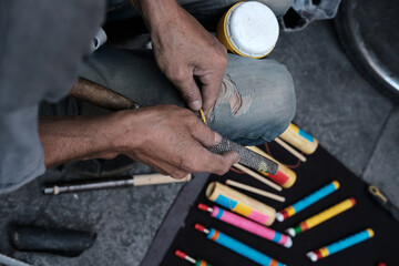 Close shot of street artist with tool in his hand