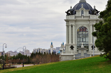 View from the side of the building of the Palace of landowners against the background of the mosque on a cloudy day. Russia Kazan 24.04.2021. High quality photo