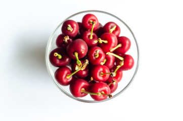 ripe cherry in a glass on a light background, free space