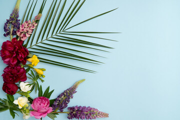 Fresh spring flowers arrangement on blue background with copy space
